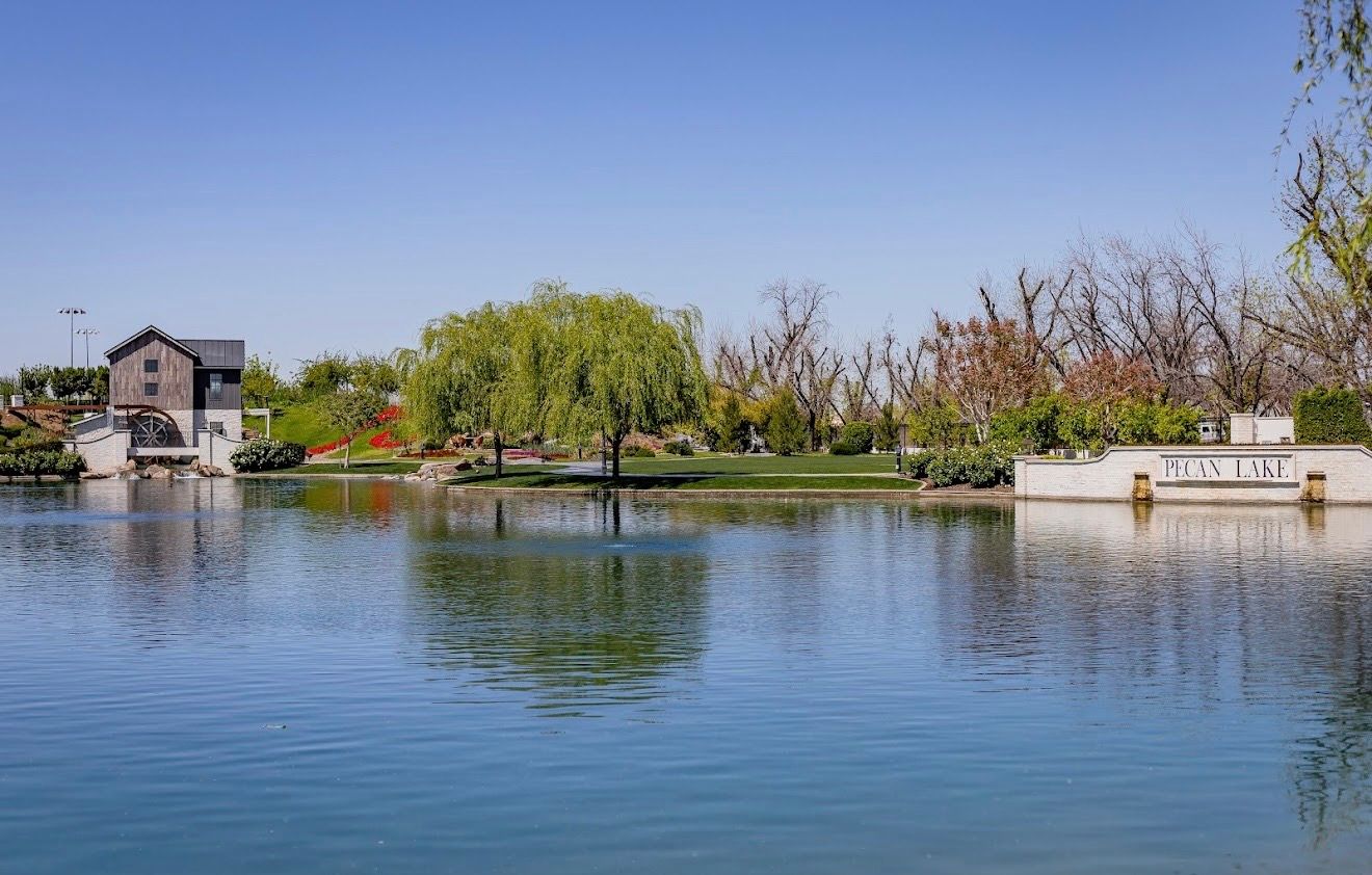 The lake with the Pecan Lake sign wall on the far bank