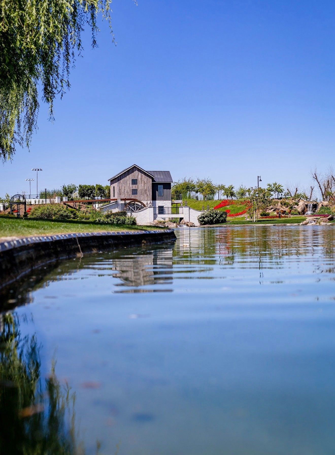 The mill across the lake from the waterline, reflected in the flat water
